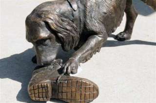 Description: This is a bronze dog playing with shoe statue. This has 